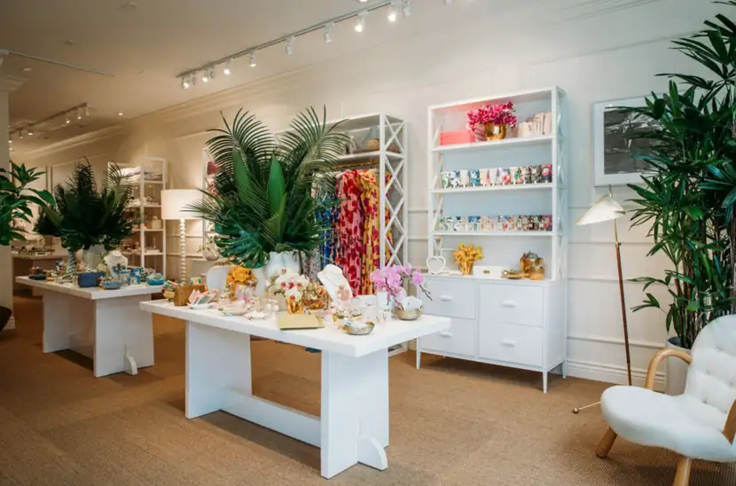 Wide view of the shop floor with white display tables and tropical greenery