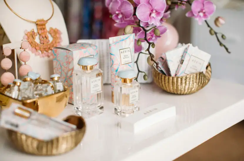 Gold trays and fragrance bottles styled with orchids on a white display table