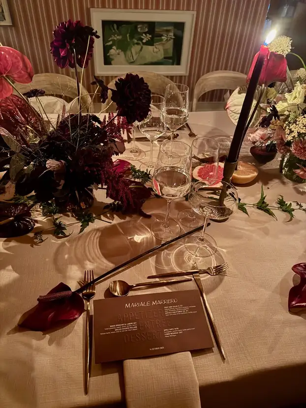Place setting detail with dahlias, tapered candles and a printed menu card