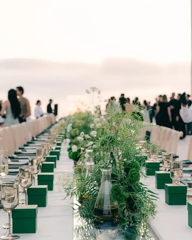A long table running the length of the courtyard, set in white linen and greenery