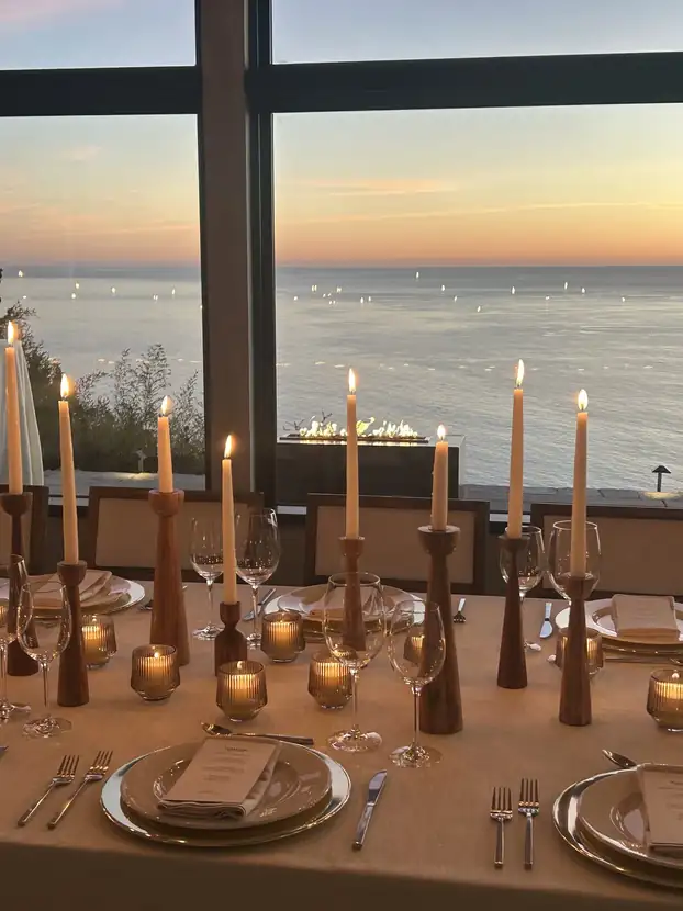 Place setting detail with white orchids, crystal votives and a printed menu