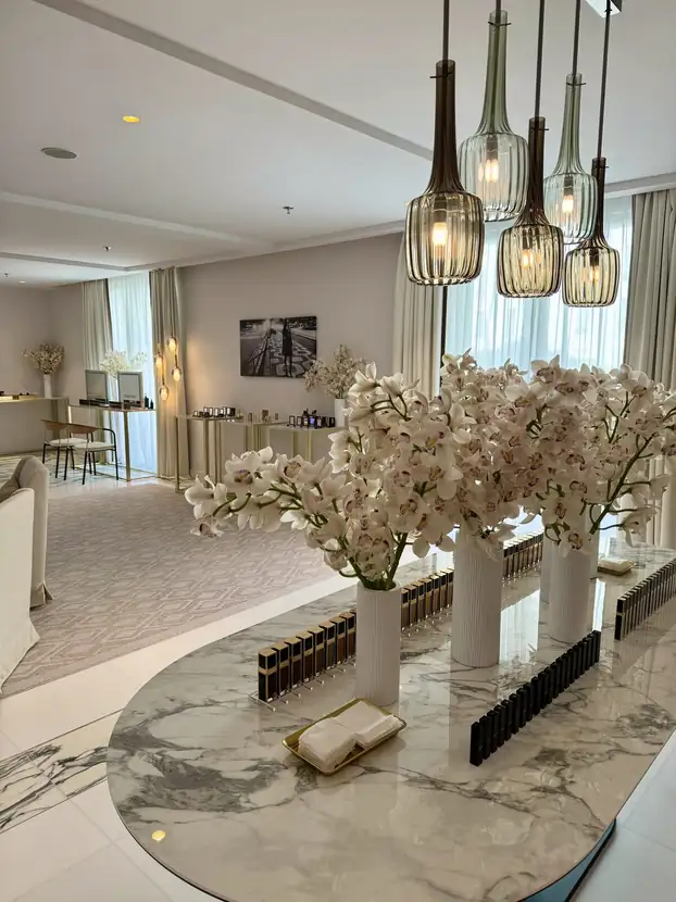 Suite lounge with sculptural pendant lights, a marble table and white blossom branches