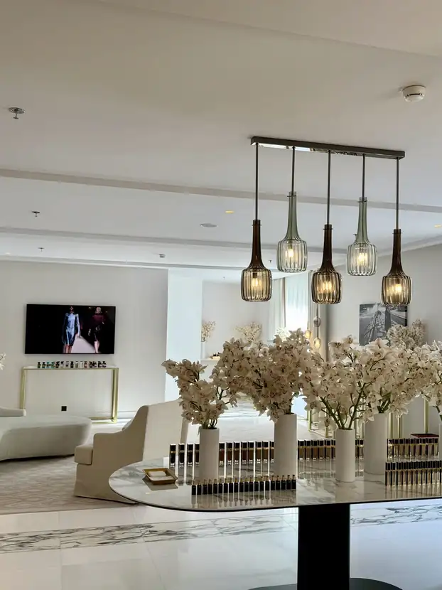Round marble table crowned with white blossom branches in the suite lounge