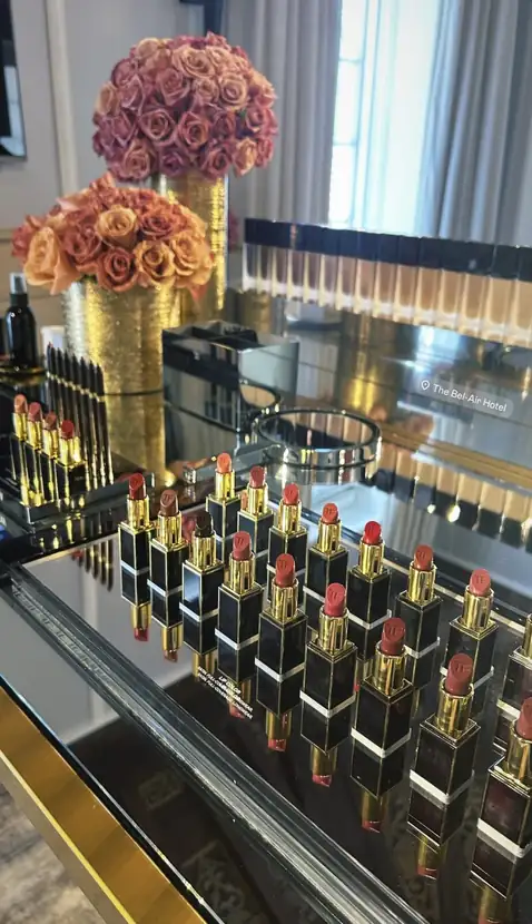 A precise row of lipsticks lining a mirrored console beneath a sculptural mirror