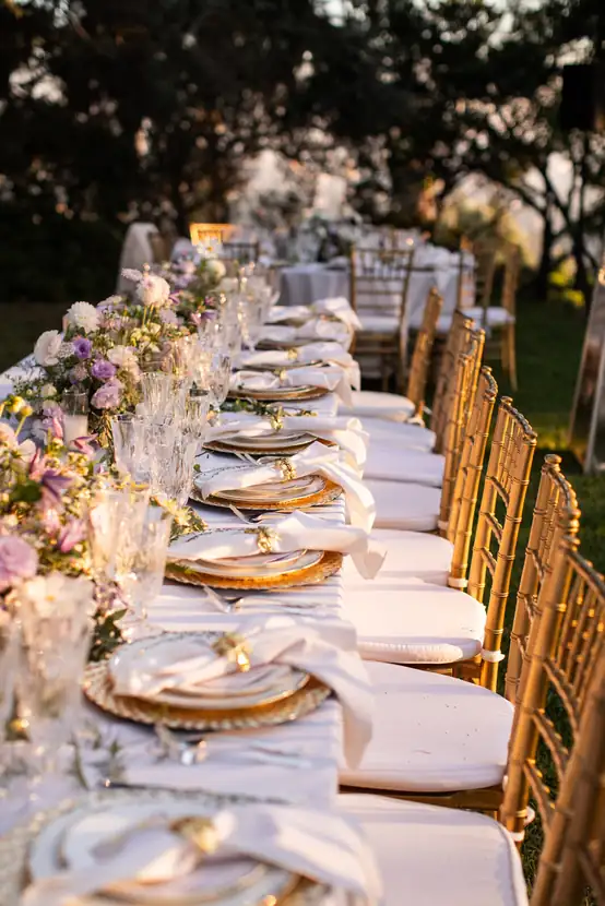 Long reception table set with gold chargers and trailing garden florals